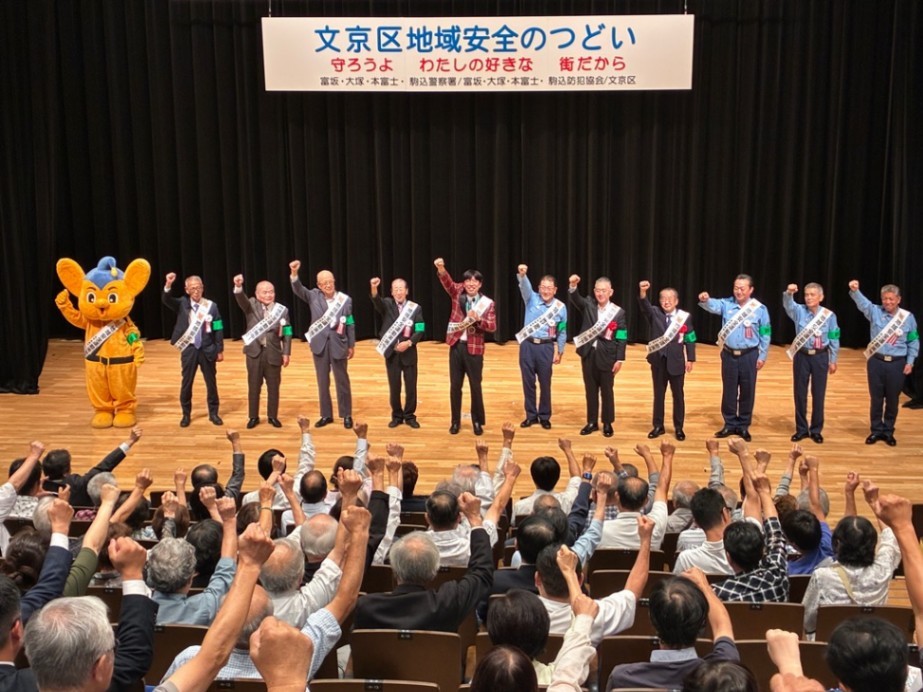 会場にいる人たちと拳を掲げている様子