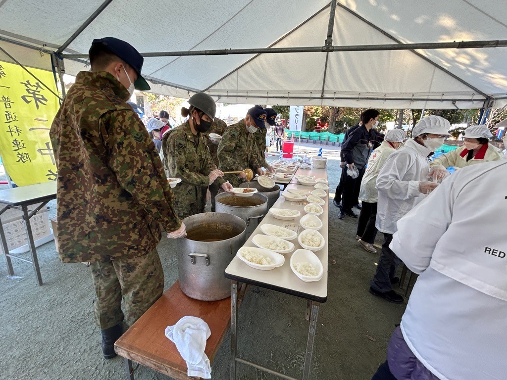 炊き出しのカレーを盛り付けている様子