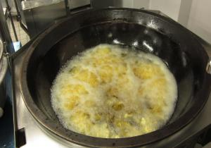 芋を油で揚げている様子